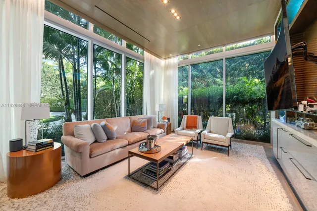 a living room with patio furniture and a floor to ceiling window