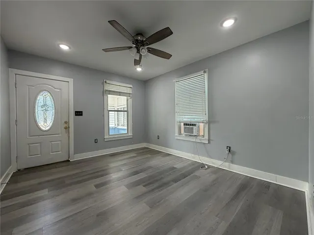 an empty room with wooden floor and window