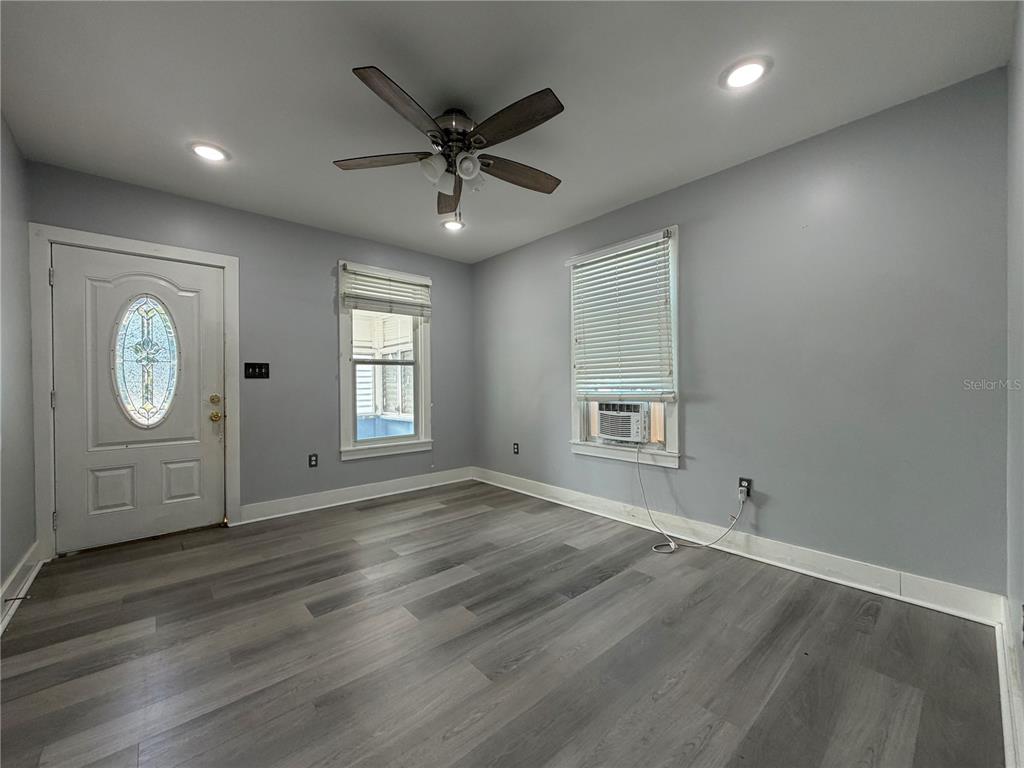 335 Maple Street Daytona Beach, FL 32114 - Photo 4 of 13 an empty room with wooden floor and window