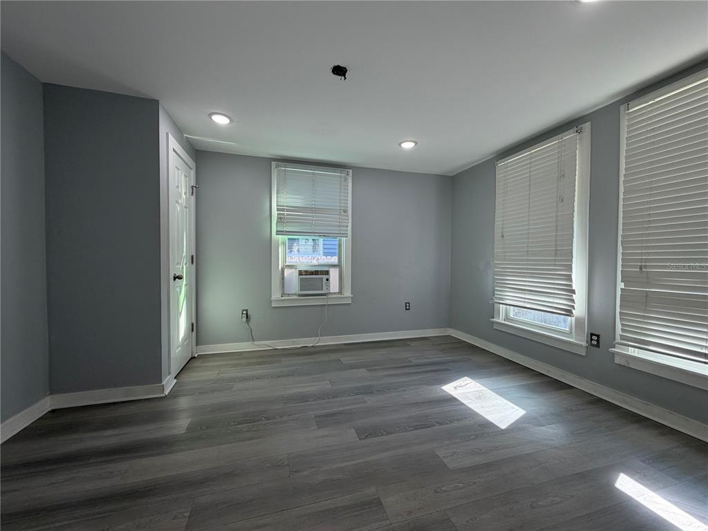 335 Maple Street Daytona Beach, FL 32114 - Photo 5 of 13 an empty room with wooden floor and windows