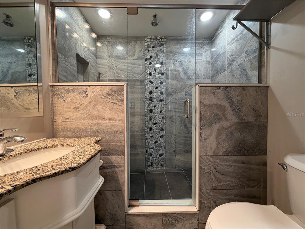 335 Maple Street Daytona Beach, FL 32114 - Photo 7 of 13 a bathroom with a sink a toilet a shower and a mirror