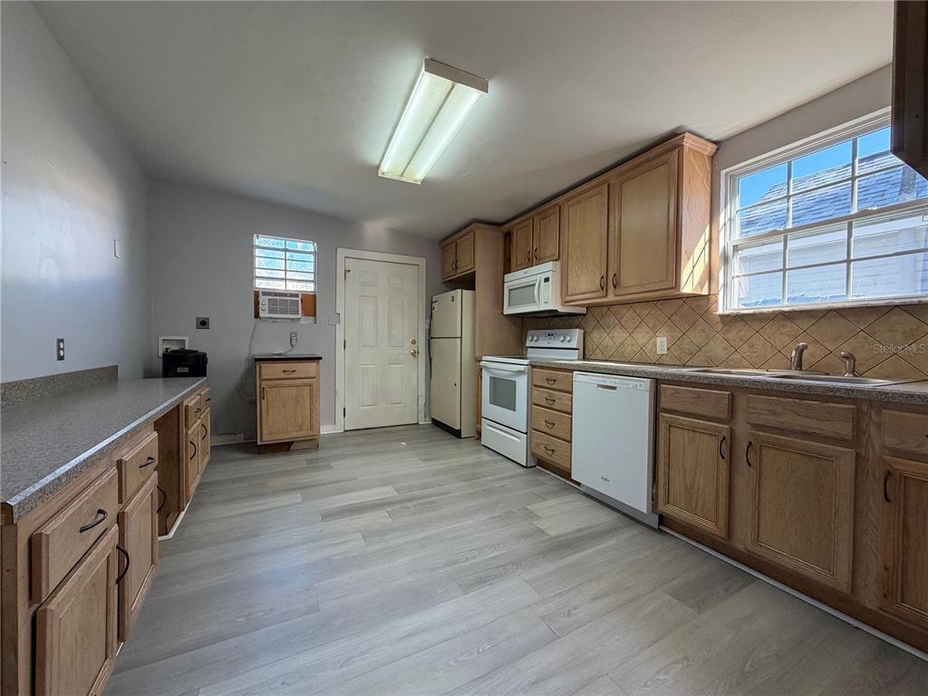 335 Maple Street Daytona Beach, FL 32114 - Photo 8 of 13 a kitchen with a sink cabinets wooden floor and stainless steel appliances