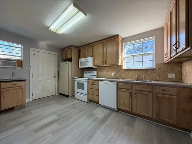 a kitchen with stainless steel appliances granite countertop a sink cabinets and wooden floor