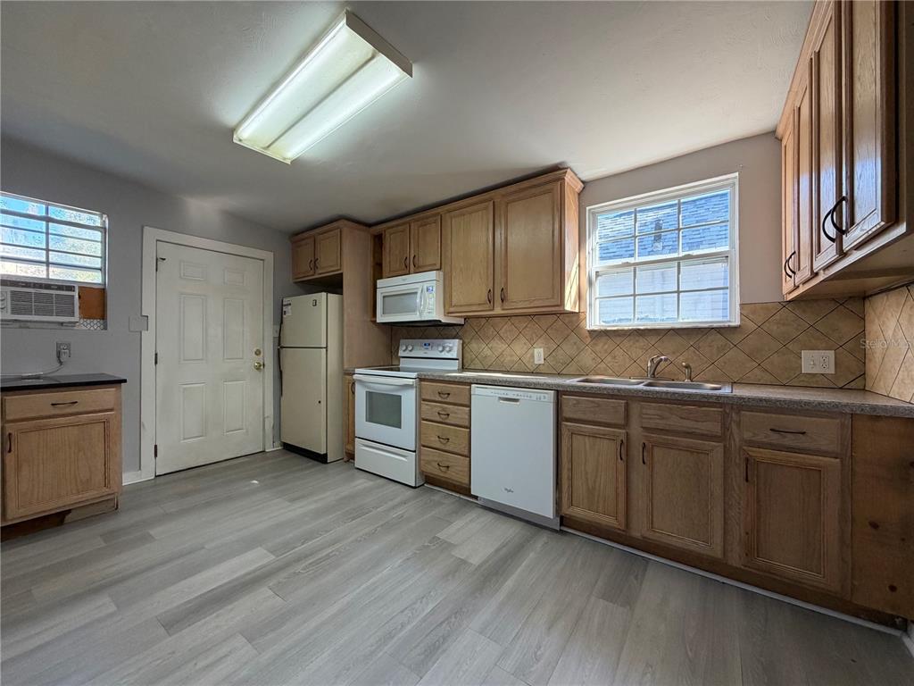 335 Maple Street Daytona Beach, FL 32114 - Photo 10 of 13 a kitchen with stainless steel appliances granite countertop a sink cabinets and wooden floor