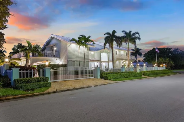 a view of a house with basketball court and palm trees