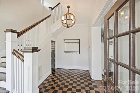 a view of a hallway with wooden floor windows and stairs
