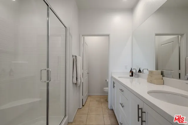 a bathroom with a double vanity sink and mirror with shower