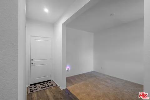 an empty room with wooden floor and white walls