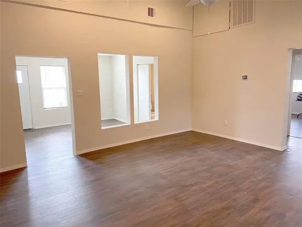 a view of a room with wooden floor and white walls