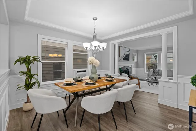 a dining room with wooden floor a chandelier a wooden table and chairs