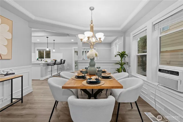 a dining room with wooden floor a chandelier a wooden table and chairs