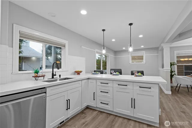 a kitchen with white cabinets and sink
