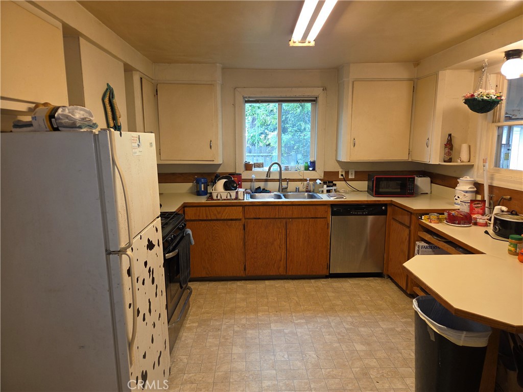 300 Chestnut Avenue Red Bluff, CA 96080 - Photo 11 of 48 a kitchen with a sink a stove a refrigerator a washer dryer and a window