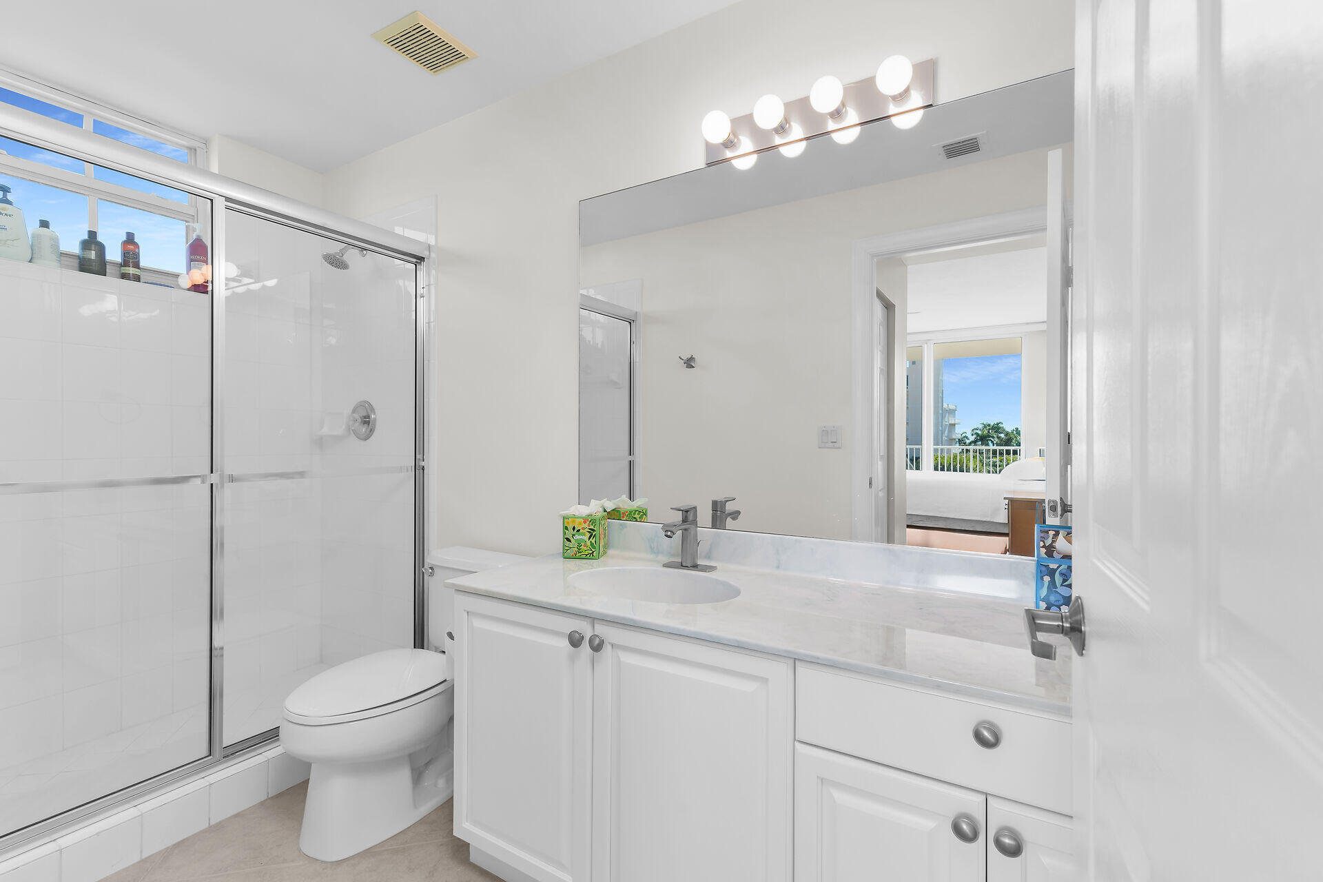 1111 Swallow Avenue, Unit 1401 Marco Island, FL 34145 - Photo 35 of 36 a bathroom with a granite countertop sink a toilet a mirror and shower