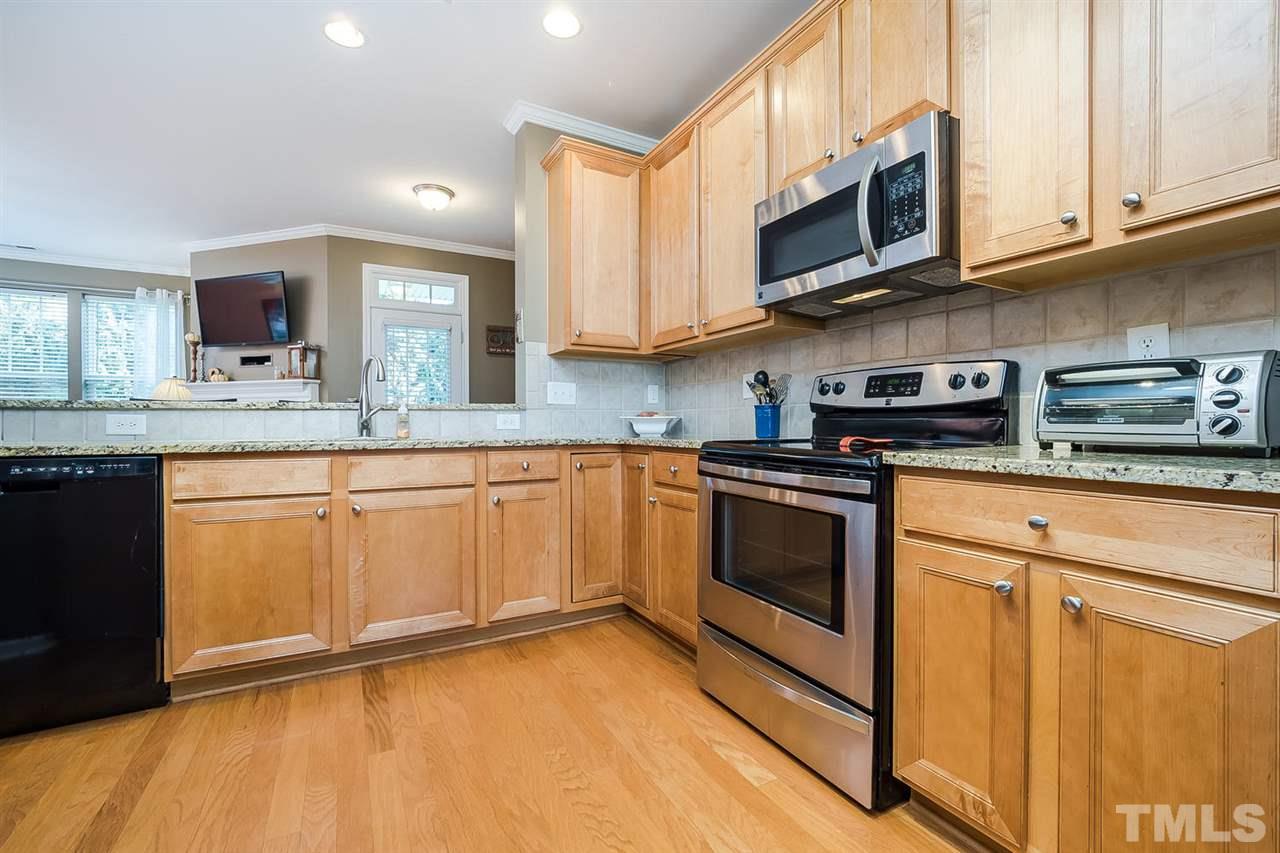 5708 Cameo Glass Way Raleigh, NC 27612 - Photo 4 of 23 a kitchen with stainless steel appliances granite countertop a stove a sink and a microwave