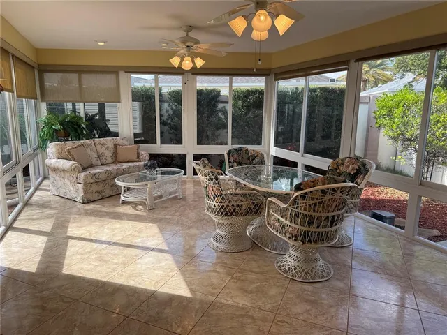 a living room with patio furniture and a large window