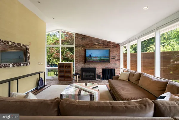 a living room with furniture a flat screen tv and a large window