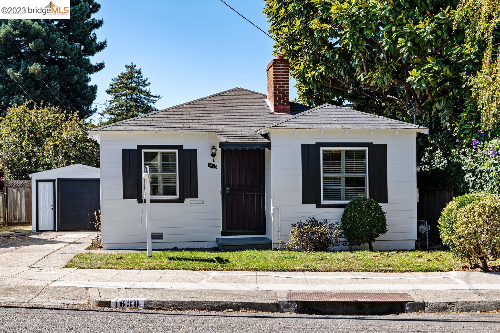 a front view of a house with garage and plants