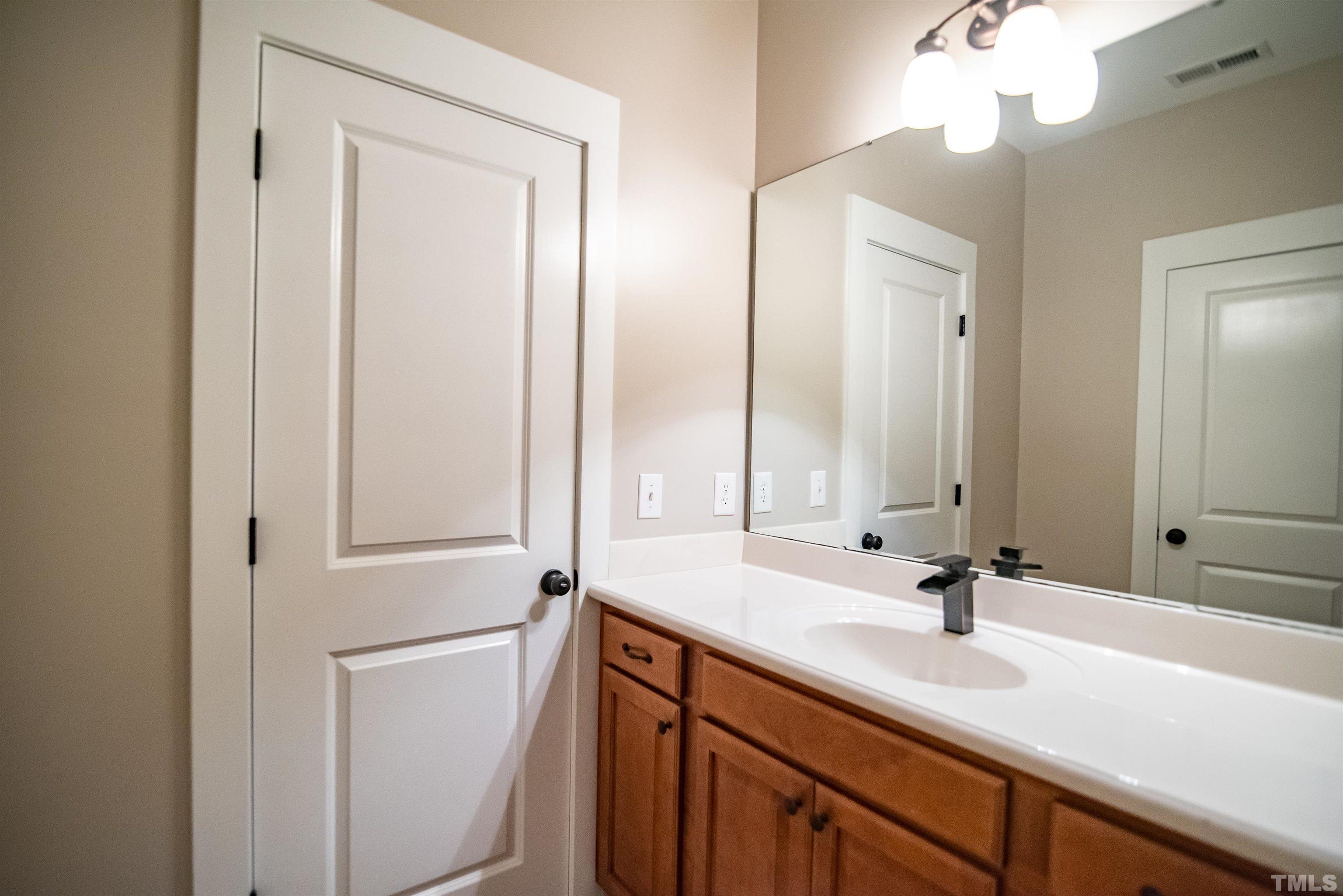 15004 Massimo Dr. Wake Forest, NC 27587 - Photo 17 of 27 a bathroom with a sink and a mirror