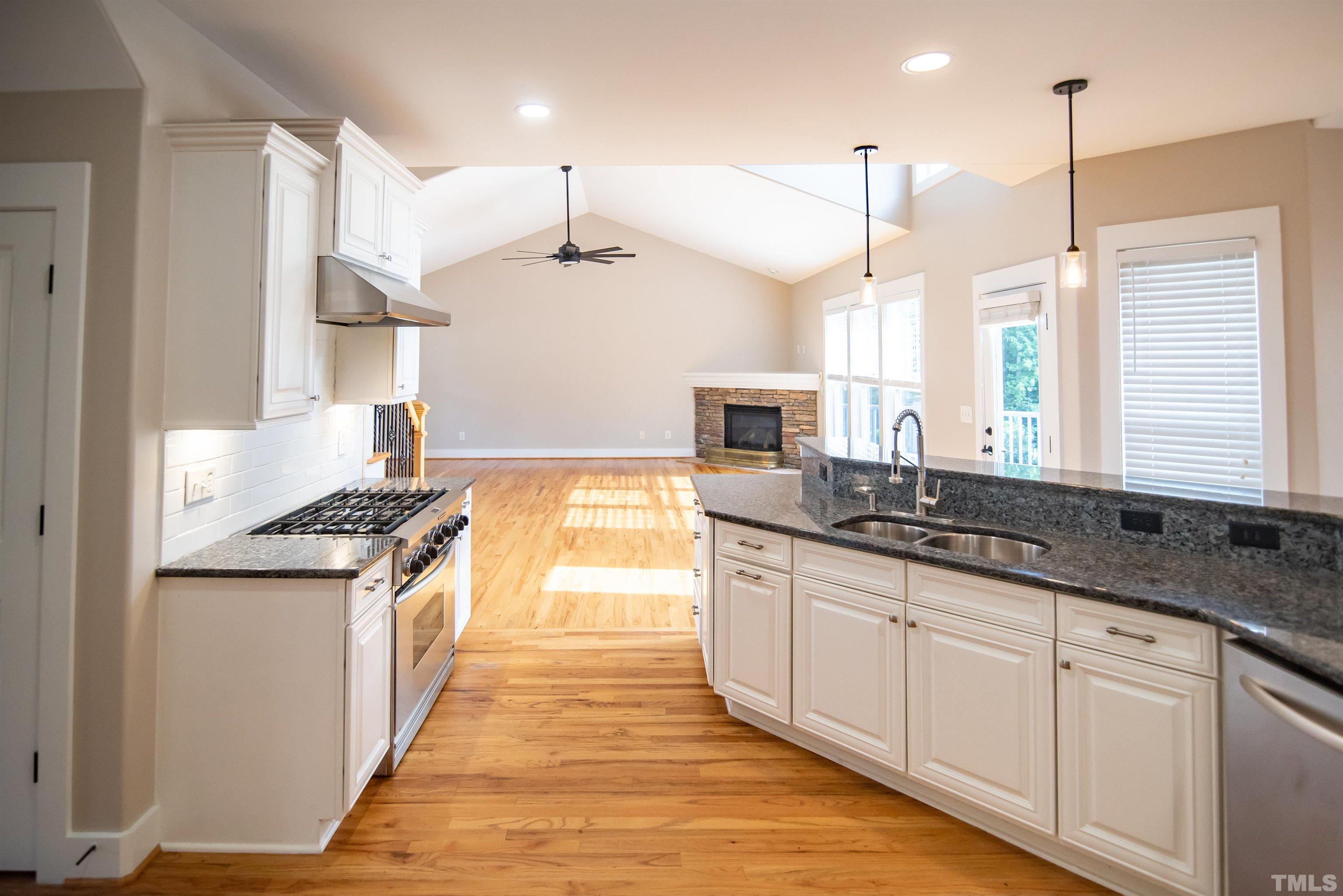 15004 Massimo Dr. Wake Forest, NC 27587 - Photo 8 of 27 a kitchen with stainless steel appliances granite countertop a sink a stove and a wooden floors