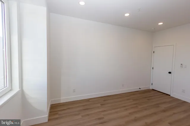 a view of room with wooden floor and white walls