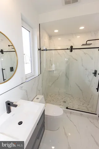 a bathroom with a sink a toilet and shower