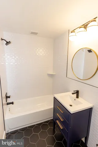 a bathroom with a sink mirror vanity and a bathtub