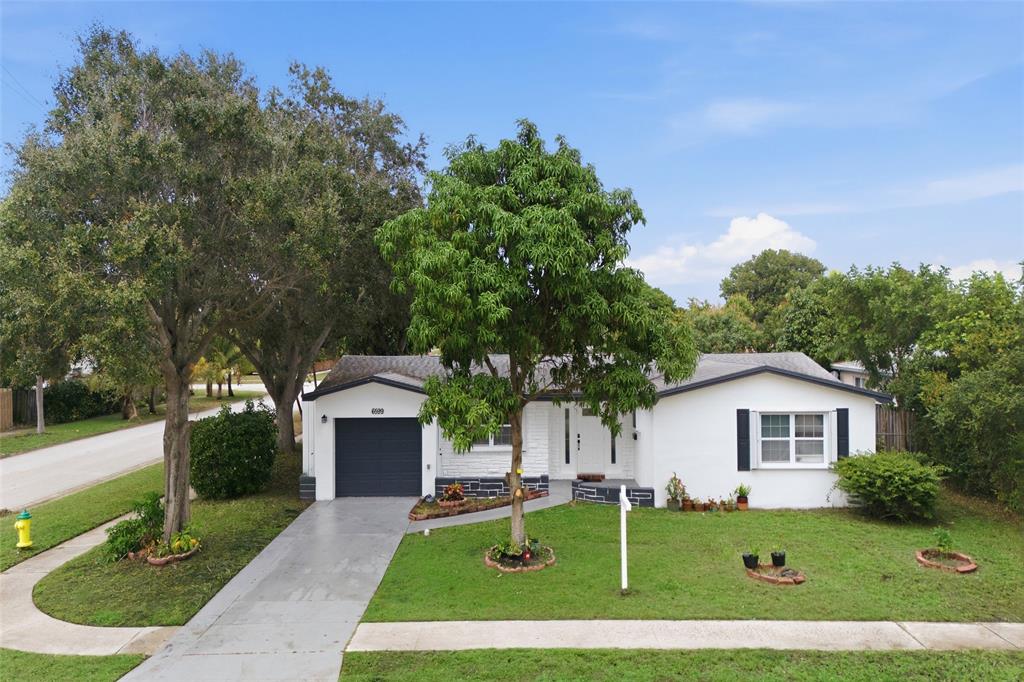 6599 Northwest 1st Street Margate, FL 33063 - Photo 1 of 43 a front view of a house with a yard and trees