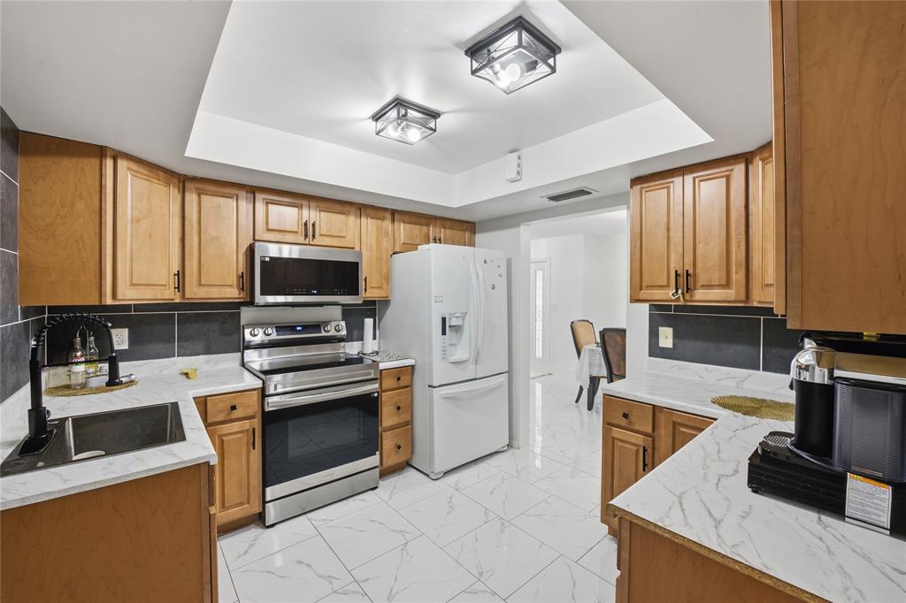 6599 Northwest 1st Street Margate, FL 33063 - Photo 14 of 43 a kitchen with stainless steel appliances granite countertop a refrigerator stove microwave and sink