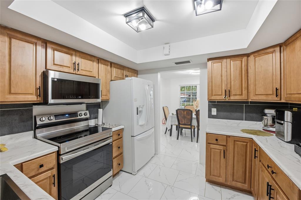 6599 Northwest 1st Street Margate, FL 33063 - Photo 15 of 43 a kitchen with stainless steel appliances a stove microwave and a refrigerator