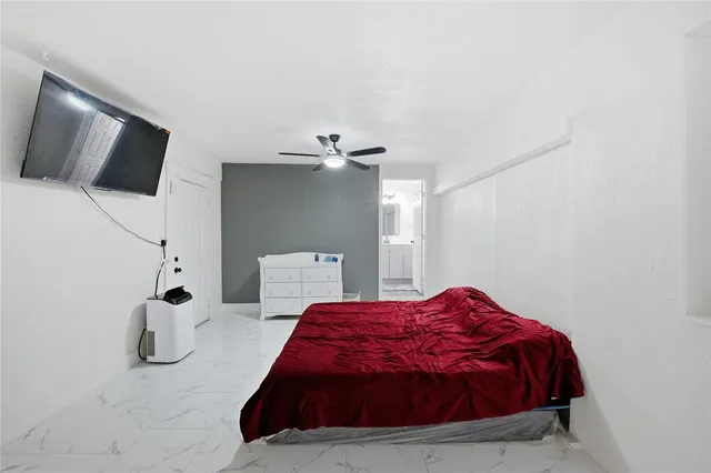 a bedroom with a bed and flat screen tv