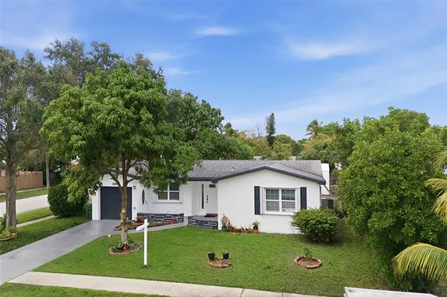 a front view of a house with a yard and trees
