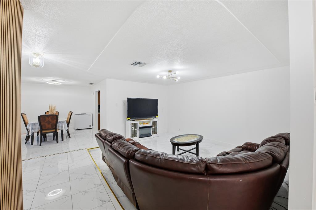 6599 Northwest 1st Street Margate, FL 33063 - Photo 22 of 43 a living room with furniture and a flat screen tv