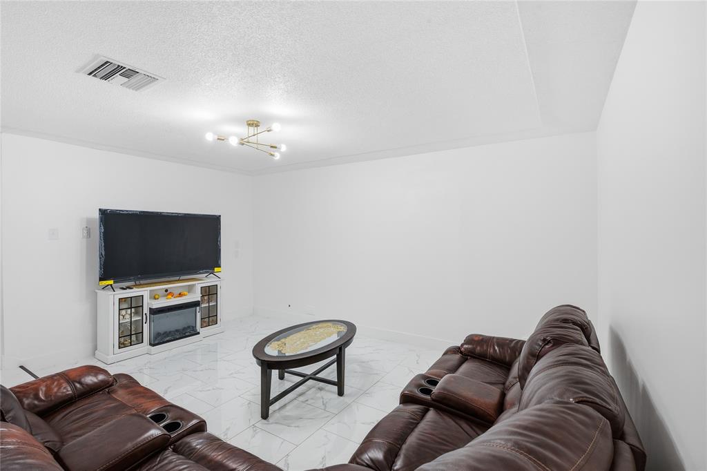 6599 Northwest 1st Street Margate, FL 33063 - Photo 23 of 43 a living room with furniture and a flat screen tv