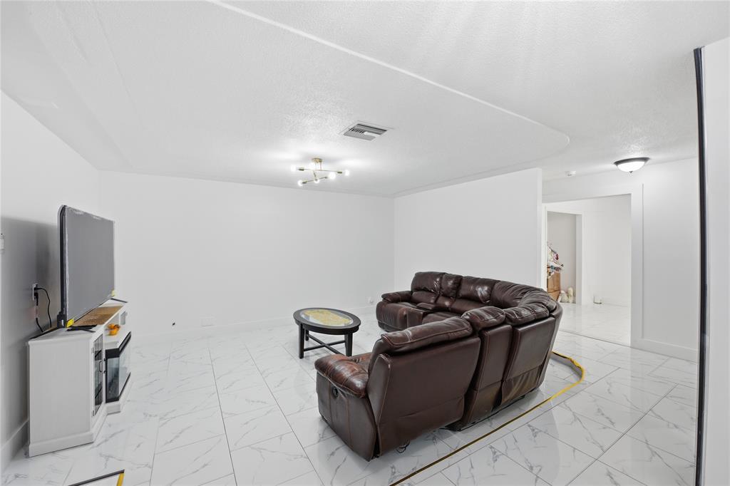 6599 Northwest 1st Street Margate, FL 33063 - Photo 24 of 43 a living room with furniture and a flat screen tv