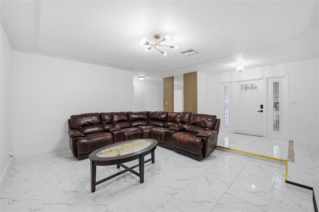 6599 Northwest 1st Street Margate, FL 33063 - Photo 26 of 43 a living room with furniture and a chandelier