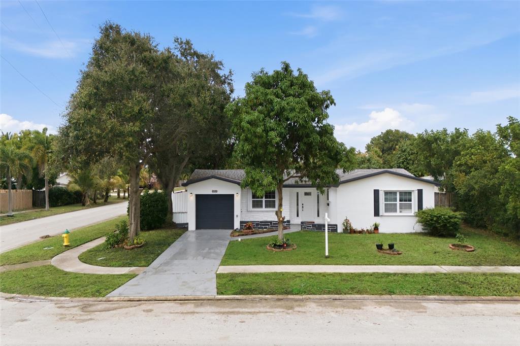 6599 Northwest 1st Street Margate, FL 33063 - Photo 3 of 43 a front view of a house with a garden and trees