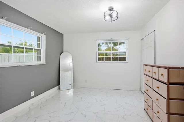 an empty room with windows and closet