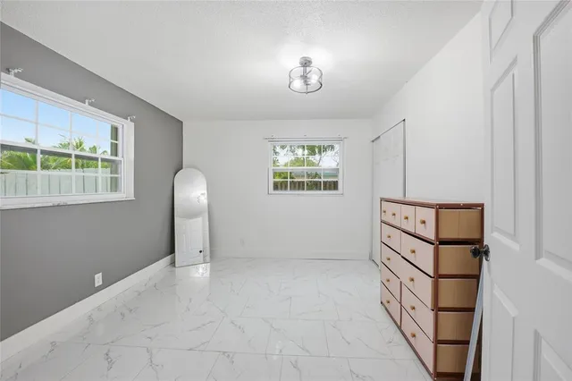 an empty room with windows and closet