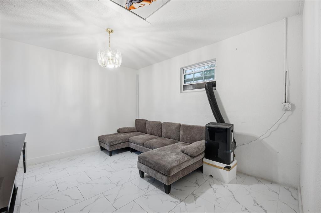 6599 Northwest 1st Street Margate, FL 33063 - Photo 10 of 43 a living room with furniture and a chandelier