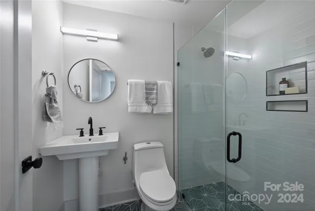 a bathroom with a toilet sink vanity tub and mirror