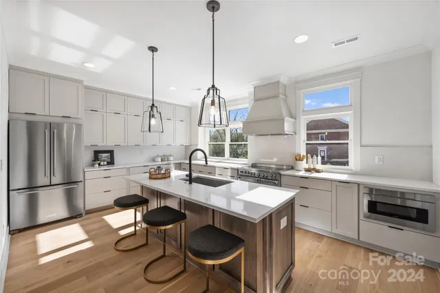 a kitchen with granite countertop a sink appliances and cabinets