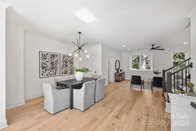 a living room with furniture a dining table and a potted plant