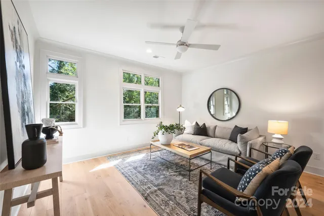 a living room with furniture a chandelier and a window