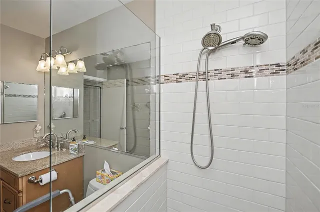 a view of a hallway with wooden floor and a refrigerator