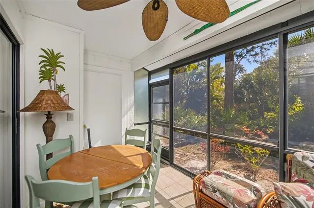 a living room with furniture a ceiling fan and a large window