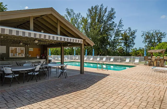 a view of a patio with table and chairs potted plants and palm trees