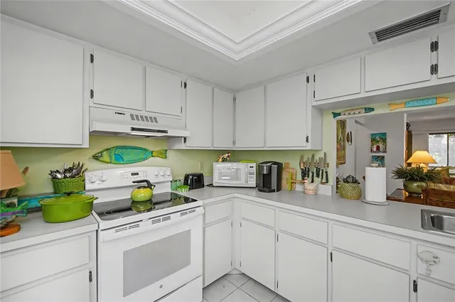 a kitchen with white cabinets and white appliances