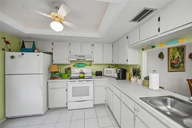 a kitchen with stainless steel appliances kitchen island granite countertop a sink and white cabinets