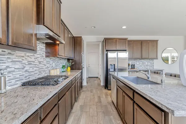 a kitchen with stainless steel appliances granite countertop a sink and stove